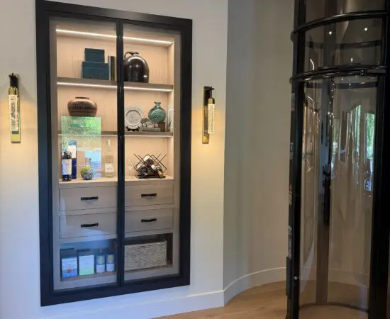 Custom built-in storage cabinets with lighting next to elevator